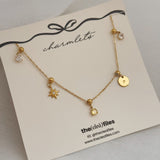 Gold necklace with star and disc pendants on a 'the clea files' branded card.
